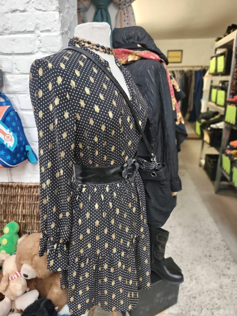 Robe et accessoires de seconde main présentés sur un buste à RE-Trouvailles, Fruges